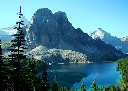 rocky mountain beside lake under blue sky thumbnail