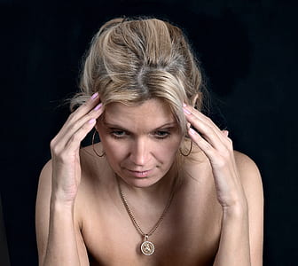 woman wearing silver-colored necklace with round pendant thumbnail