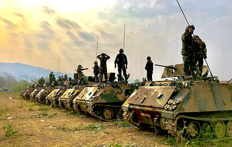 military riding on tanks thumbnail