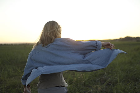 woman wearing gray long-sleeved shirt on grass field thumbnail
