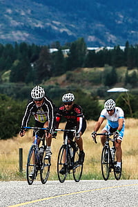 three cyclers on gray concrete road during daytime thumbnail