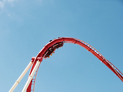 people riding on roller coaster under blue calm sky thumbnail