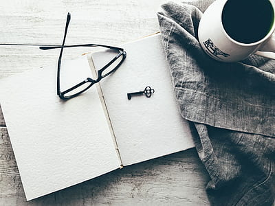 eyeglasses on white book beside key thumbnail