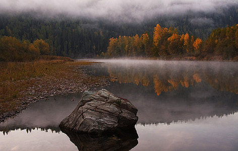 black stone fragment surrounded by body of water thumbnail