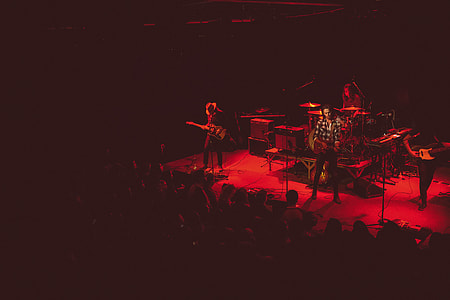 photo of music band on stage facing audience thumbnail