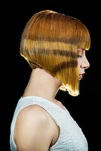side view of woman wearing white sleeveless top with bobcat hairstyle thumbnail