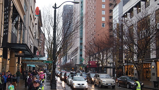 assorted vehicles stopped on highway during traffic and mass of people walking beside buildings thumbnail