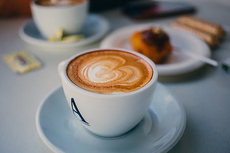 selective focus photo of cup of latte on saucer thumbnail