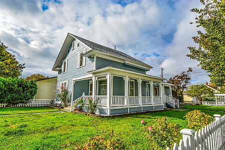 blue and white wooden house near green trees under white clouds and blue sky at daytime thumbnail