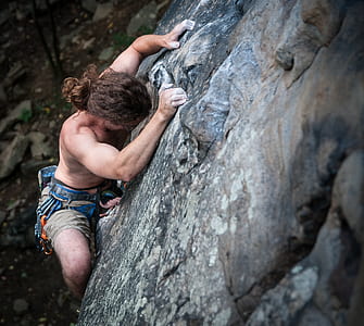 man in blue shorts climbing on wall thumbnail