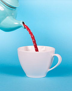 teal teapot filled with red liquid pouring white cup thumbnail