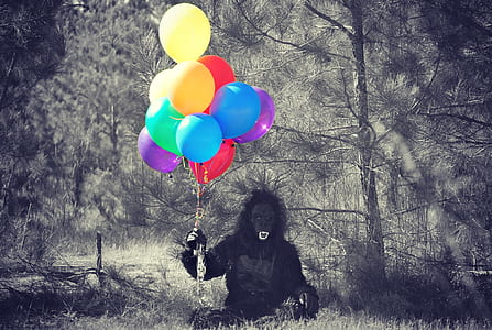 person in black gorilla costume holding balloons in forest thumbnail