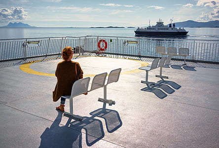 woman sat on 3-seat ganchair facing ferry boat thumbnail