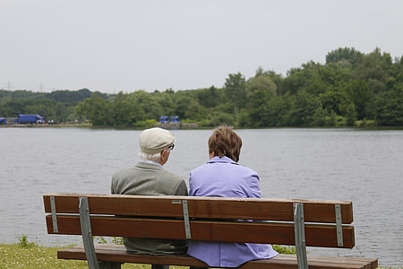 two person sitting on bench near river during day time thumbnail