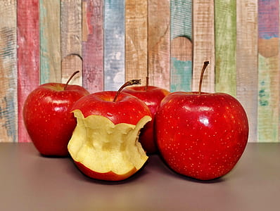four red apples on table thumbnail