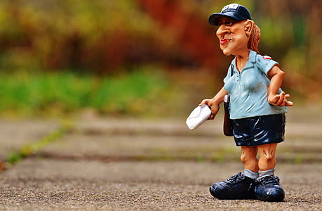 mailman figurine on gray pavement thumbnail