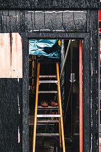 orange A-frame ladder inside black wall thumbnail