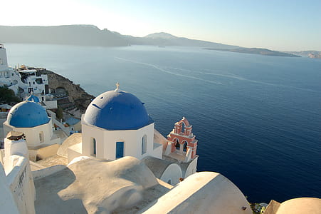white and blue Santorini dome Greece near blue sea under white sky during daytime thumbnail