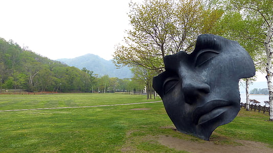 face statue near body of water during daytime thumbnail