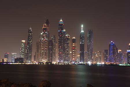 city buildings near body of water during night time thumbnail