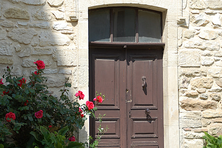 brown wooden door near red roses thumbnail