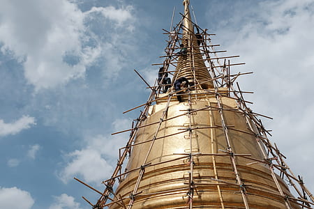low angle photography of people climbing gold structure at daytime thumbnail