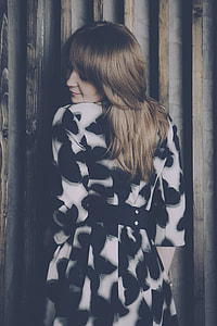 woman in black and white dress photo near wall thumbnail