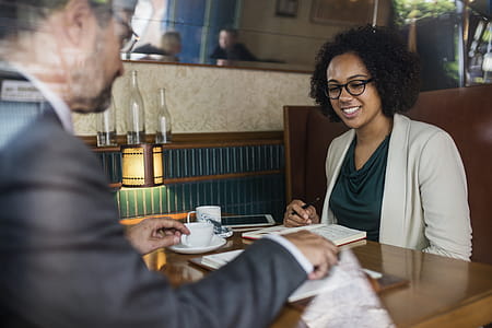 Woman Holding Pen in Front of Man Wearing Gray Suit Jacket thumbnail