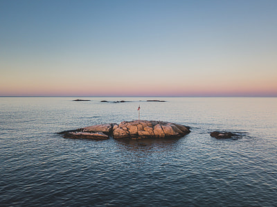 rock formation with flag during sunrise thumbnail