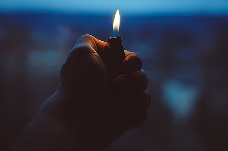 person holding lighted lighter thumbnail