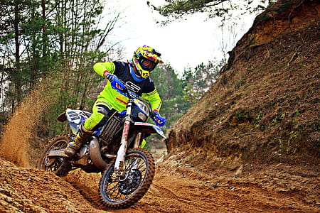 Man Riding Blue and White Dirt Bike thumbnail