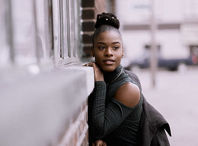 woman wearing black cold-shoulder top leaning against wall thumbnail