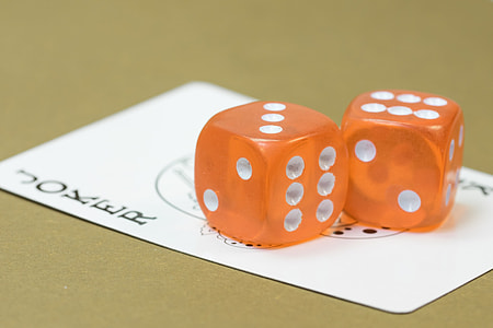 two orange dices on top of joker game card thumbnail