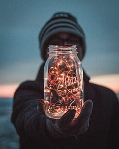 person holding a jar with red light strip inside thumbnail