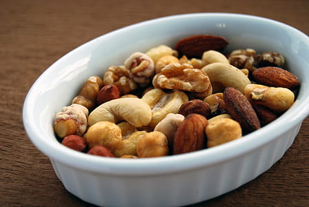 white and brown nuts in round white ceramic bowl thumbnail