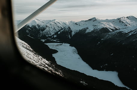 aerial photography of body of water between mountain thumbnail