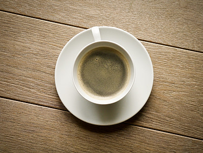 white teacup with liquid on wooden surface thumbnail