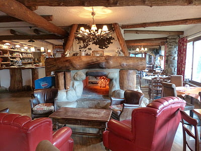 sofa, sofa chairs, and coffee table under switched-on chandelier in living room thumbnail