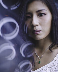 focus photography of woman in white floral lace scoop-neck top wearing silver-colored pendant necklace thumbnail
