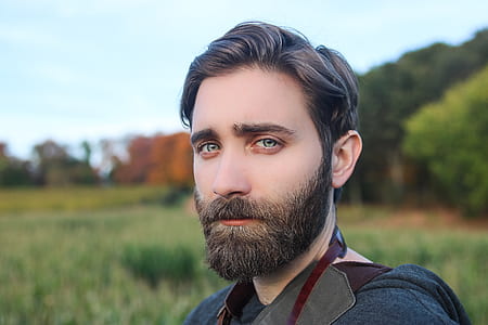 man on grass field near trees thumbnail