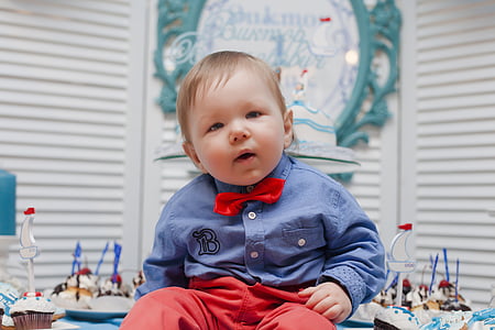 boy sitting on table near white window blinds thumbnail
