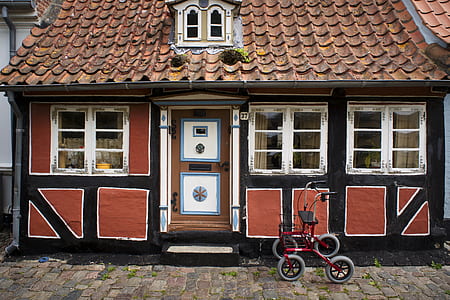 red rollator parked near brown and black house thumbnail