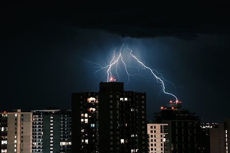 lightning striking buildings during nighttime thumbnail