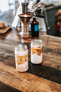selective focus photography of two clear glass bottles on brown table thumbnail