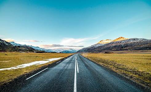 black road cleared near mountains thumbnail