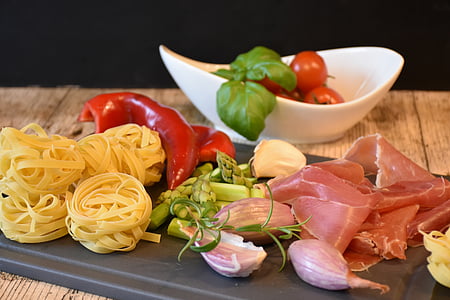pasta, bell pepper and raw meat on chopping board thumbnail