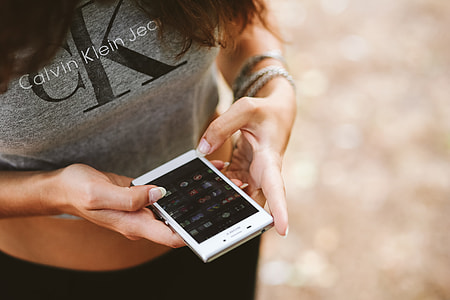Young woman holding the white mobile phone thumbnail