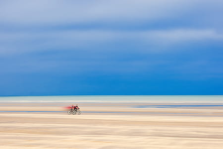 two person biking on brown sand surface painting thumbnail