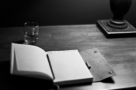 notebook on top of table monochromatic photography thumbnail