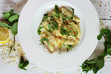 white pasta with leaves garnish on round white ceramic plate thumbnail